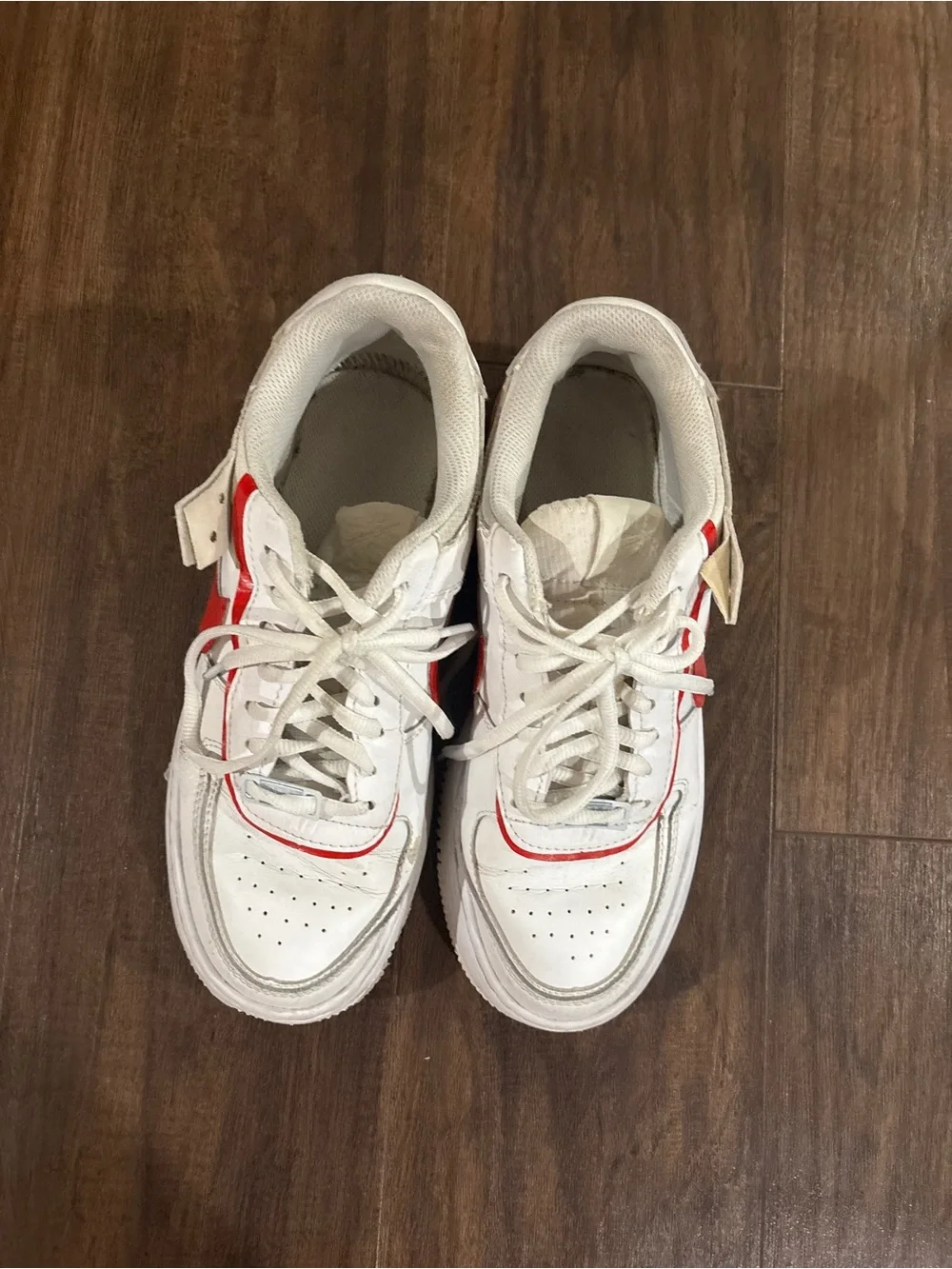 Nike Air Force 1 white sneakers with red Nike swoosh